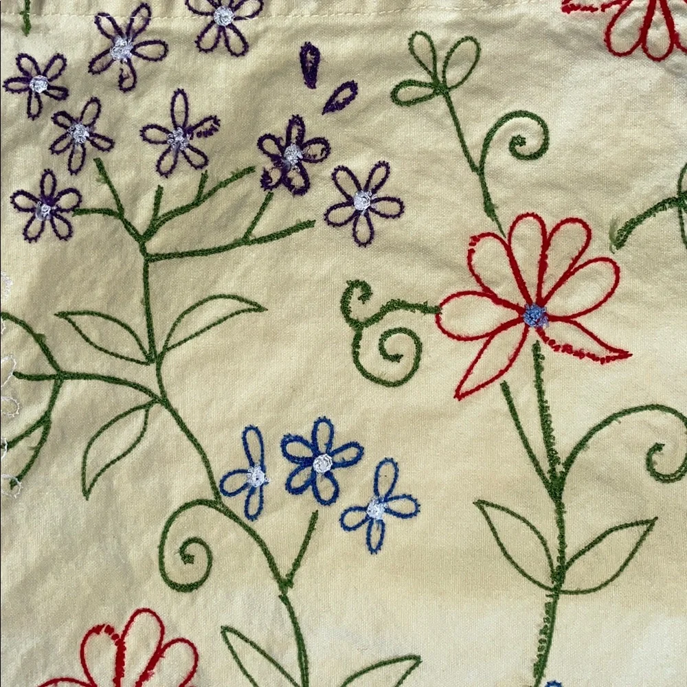 Four Crate & Barrel light yellow colorfully embroidered placemats